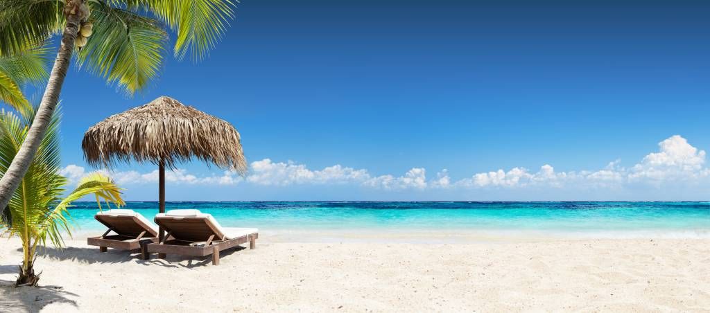 Stühle und Sonnenschirm am tropischen Strand