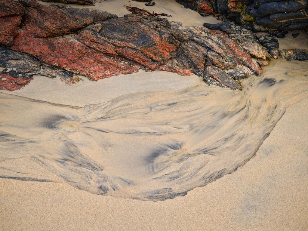 Sandfigur und Felsen