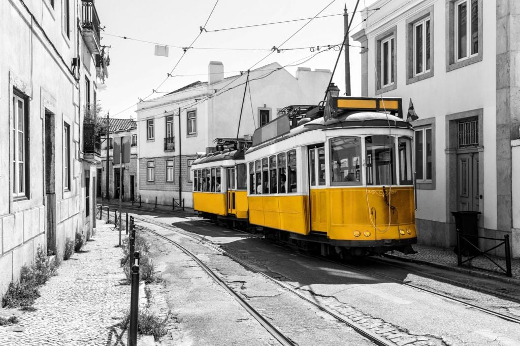 Gelbe Straßenbahn in einer schwarz-weißen Straße