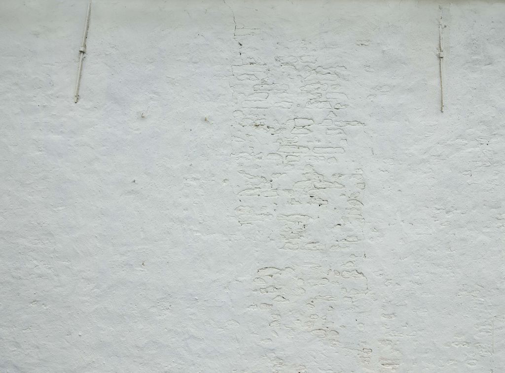 Wand mit weißem Putz und Dübeln