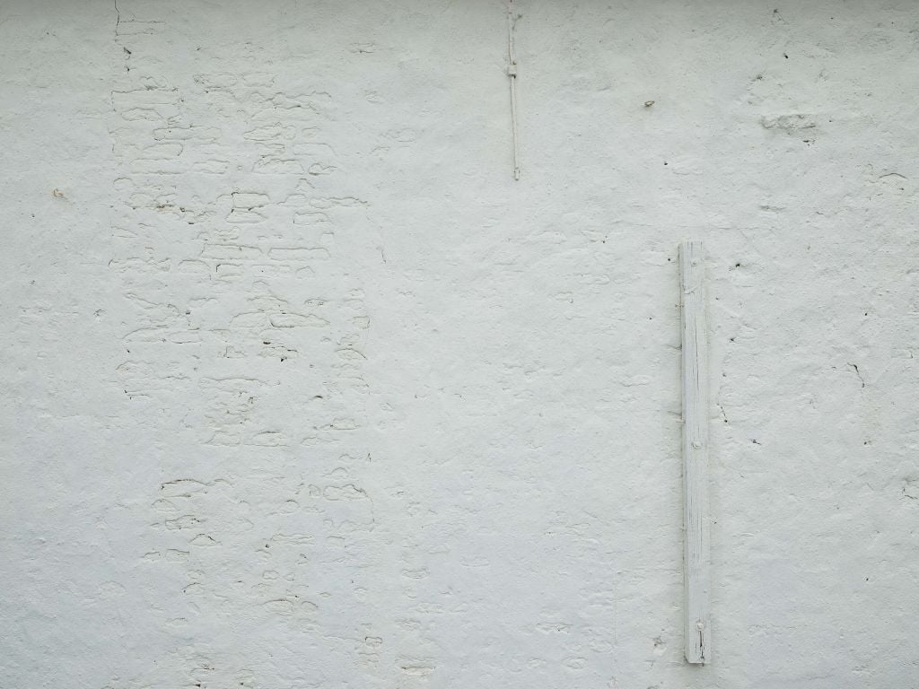 Wand mit weißem Stuck und Balken