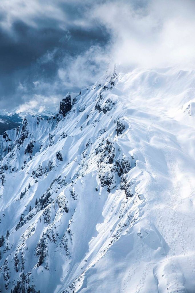 Schneekämme unter stürmischen Wolken.