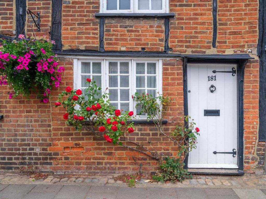 Backsteincottage mit roten Rosen