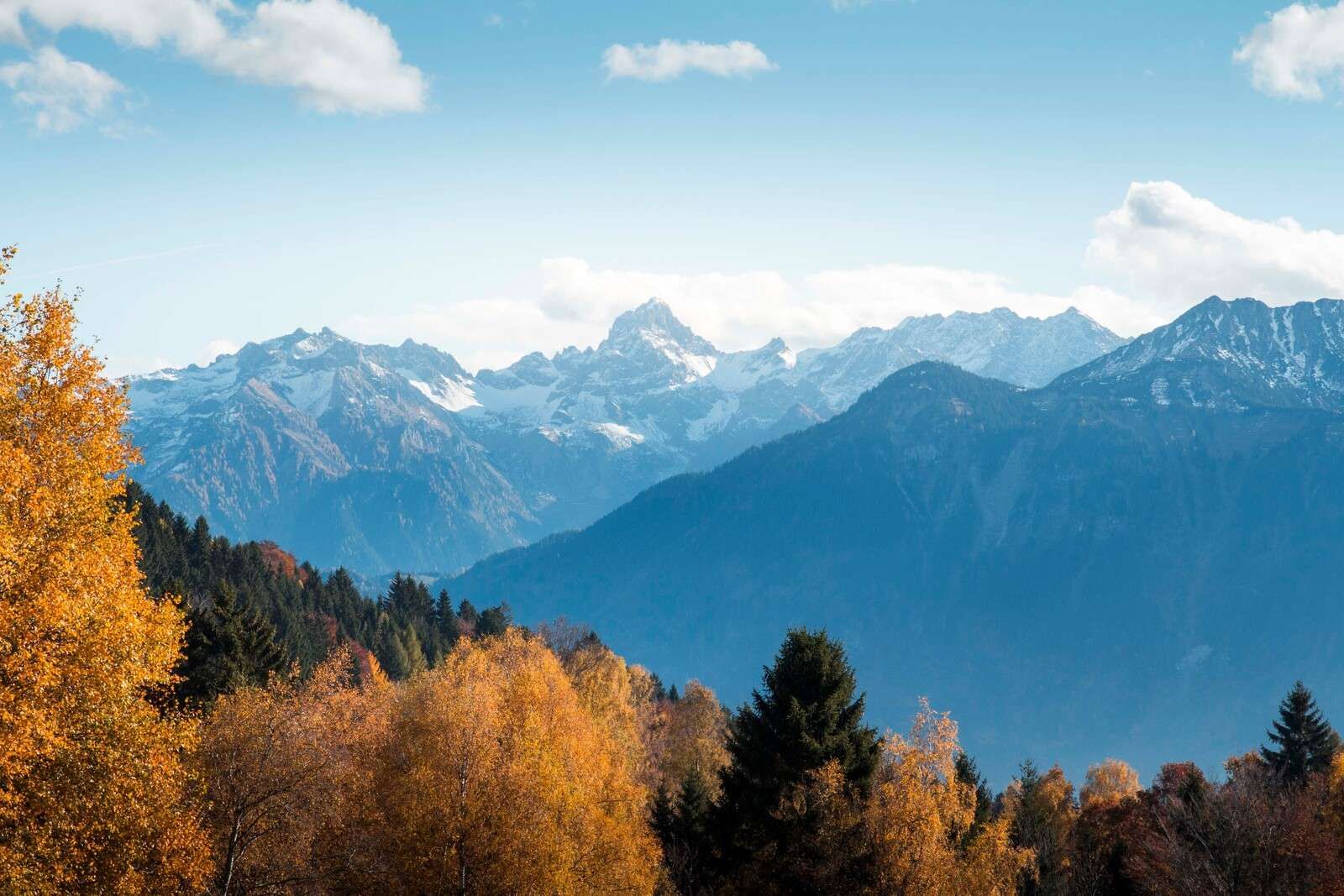 Herbstfarben für verschneite Berggipfel