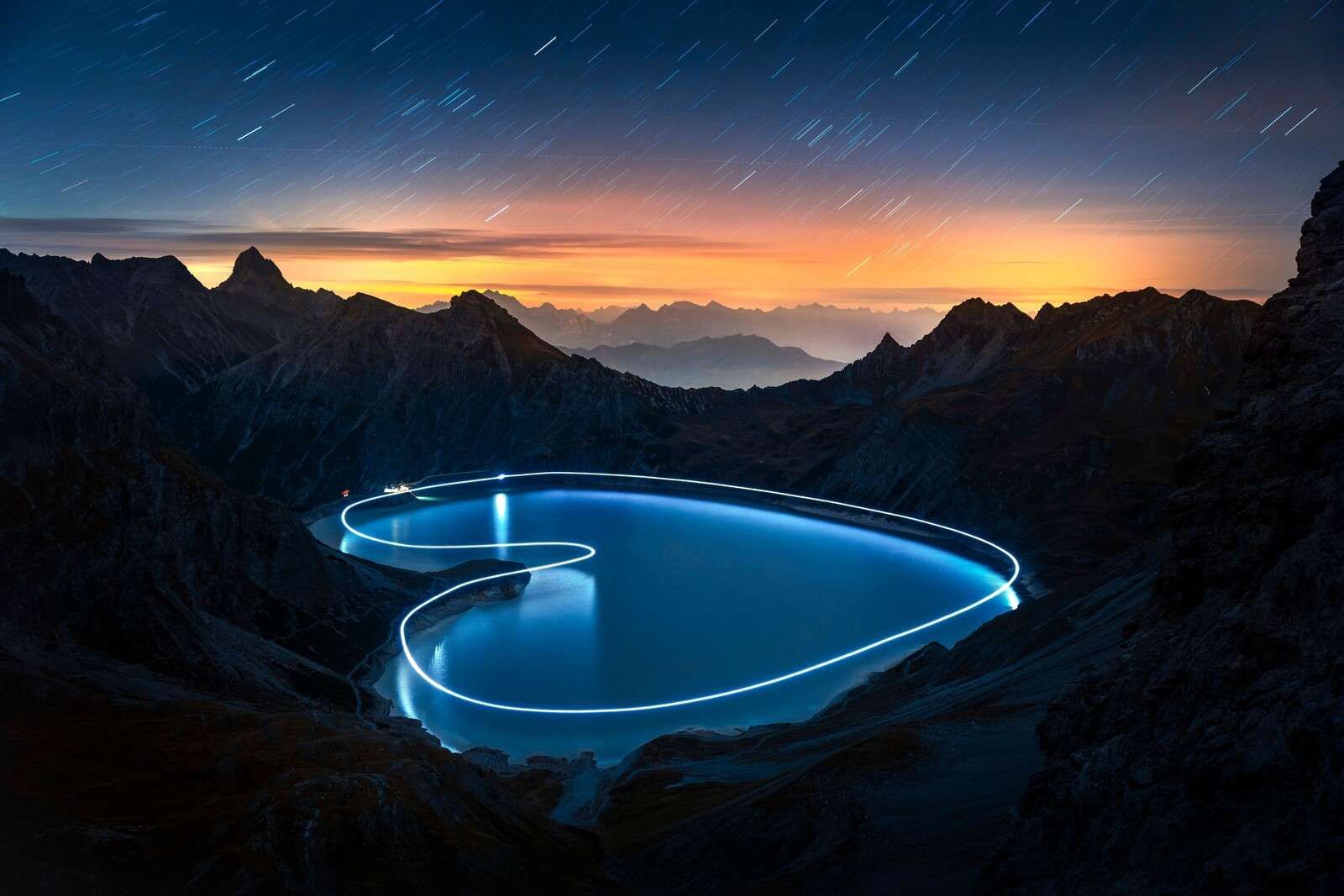 Lichtpfad um Bergsee bei Nacht