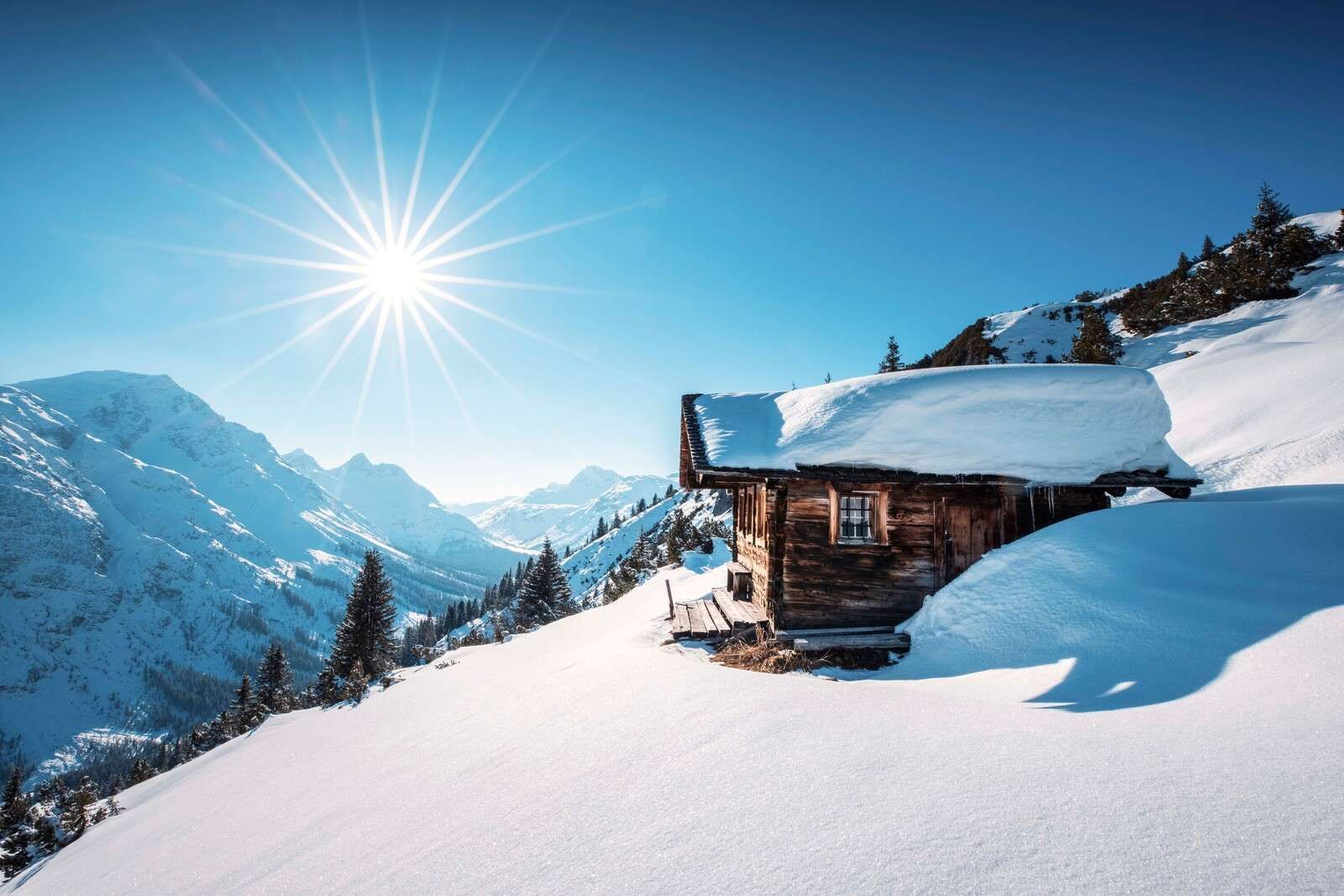 Winter Sonne über Holzhütte in den Bergen.