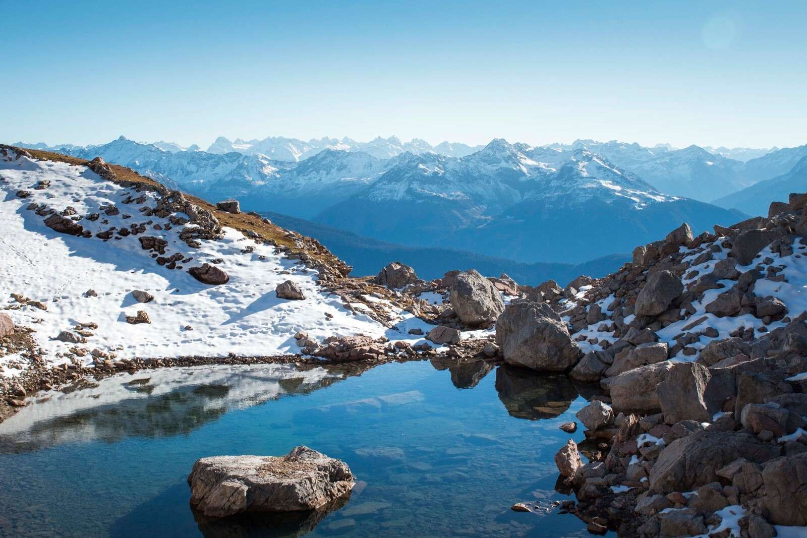 Bergsee zwischen Schneegipfeln