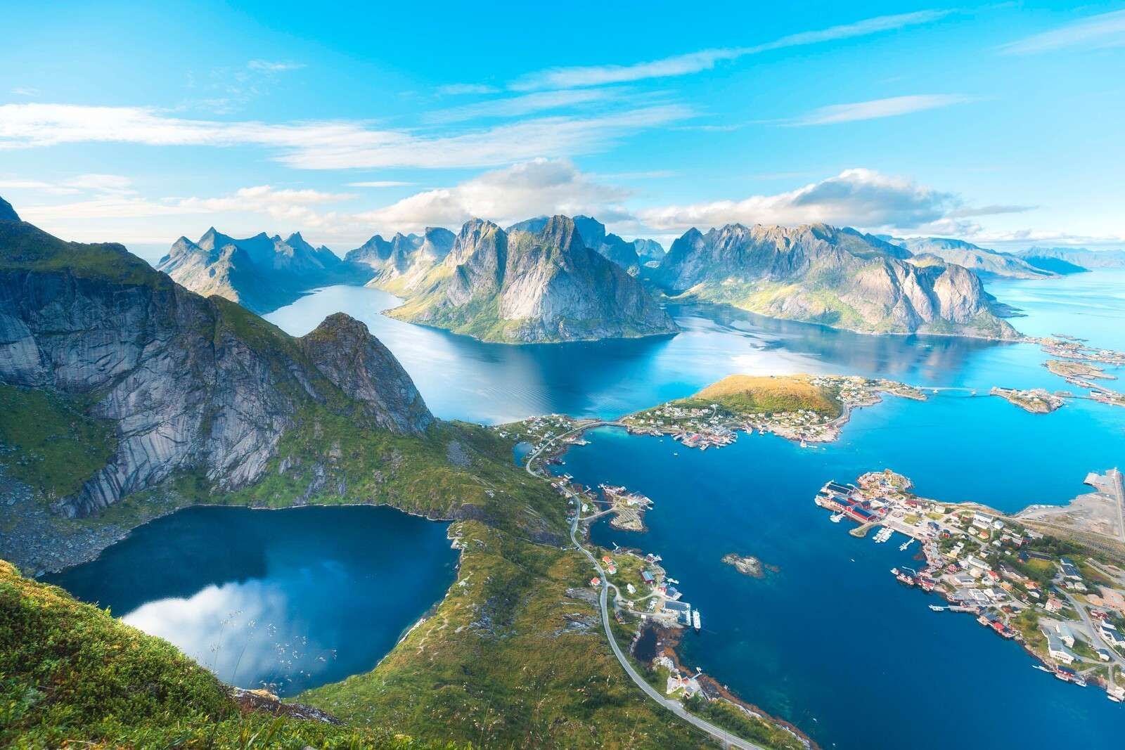 Bergsee und Fjorddorf im Sonnenlicht.