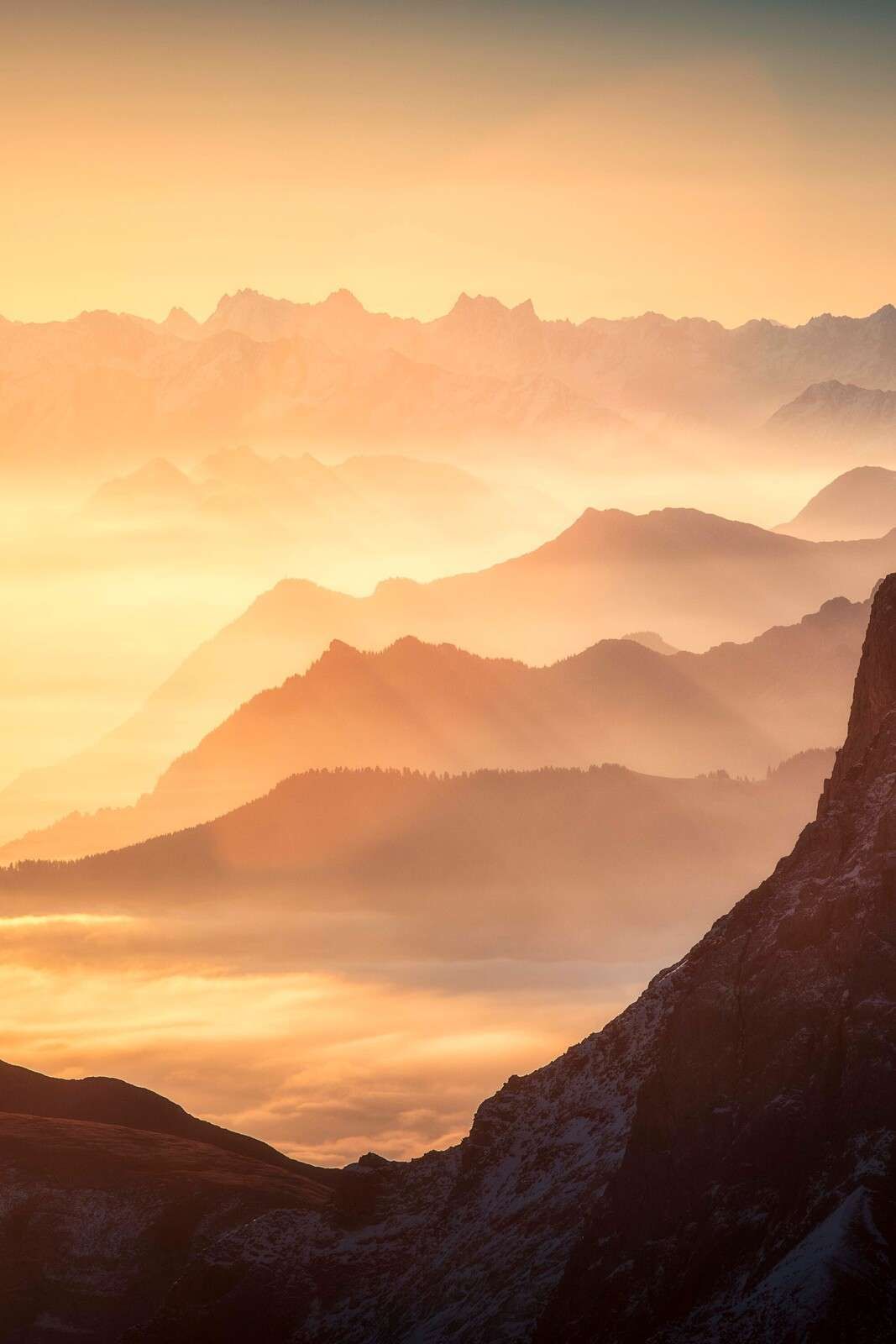 Schichtige Bergsilhouetten bei Sonnenaufgang.