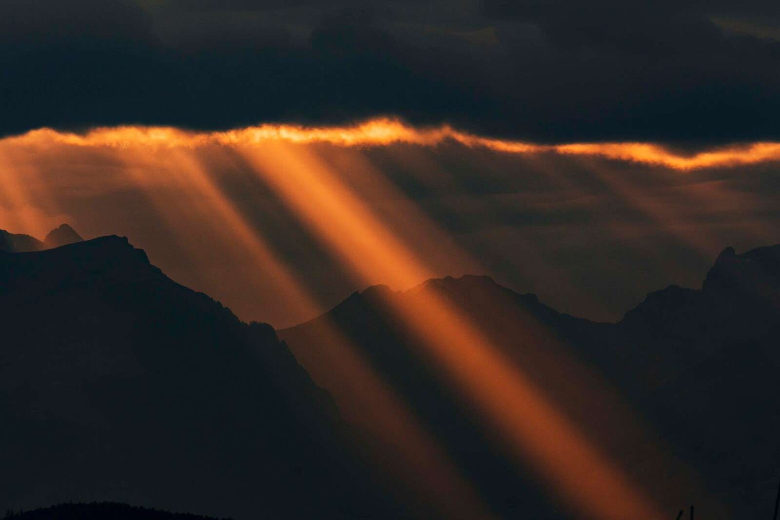 Goldene Sonnenstrahlen über Bergsilhouette