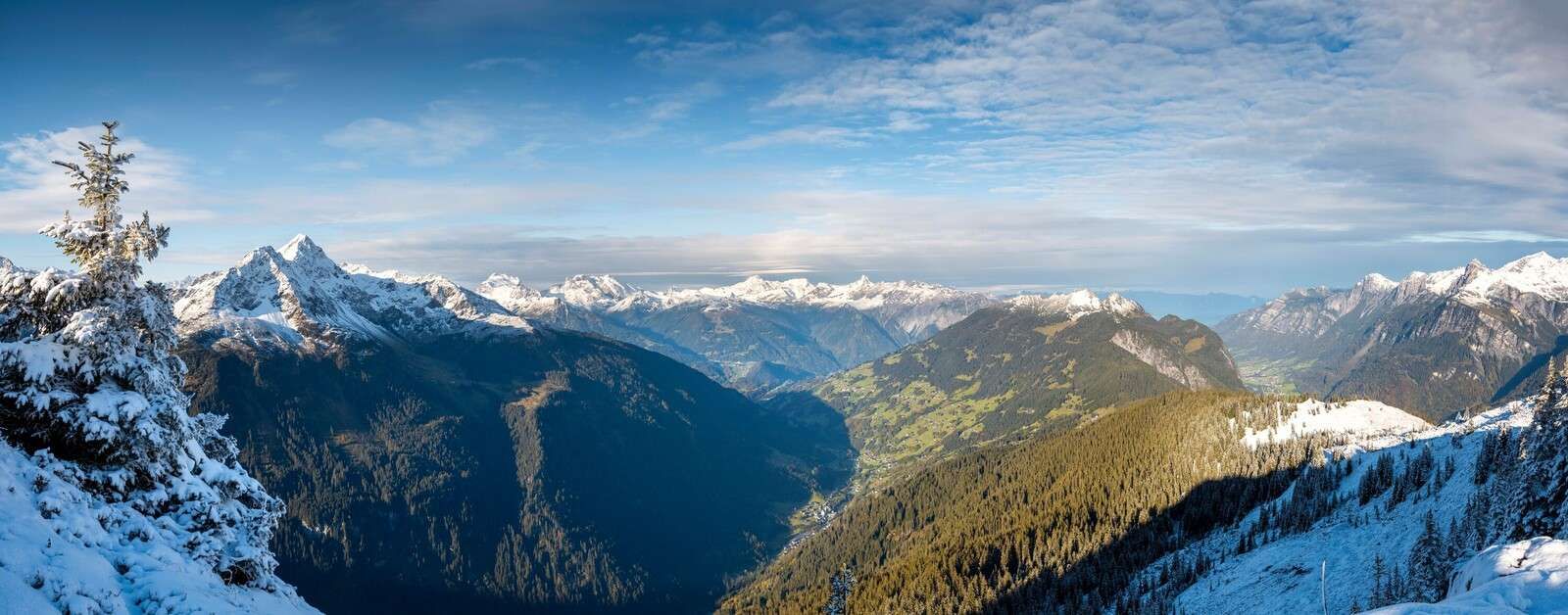 Panorama über verschneites Alpental.
