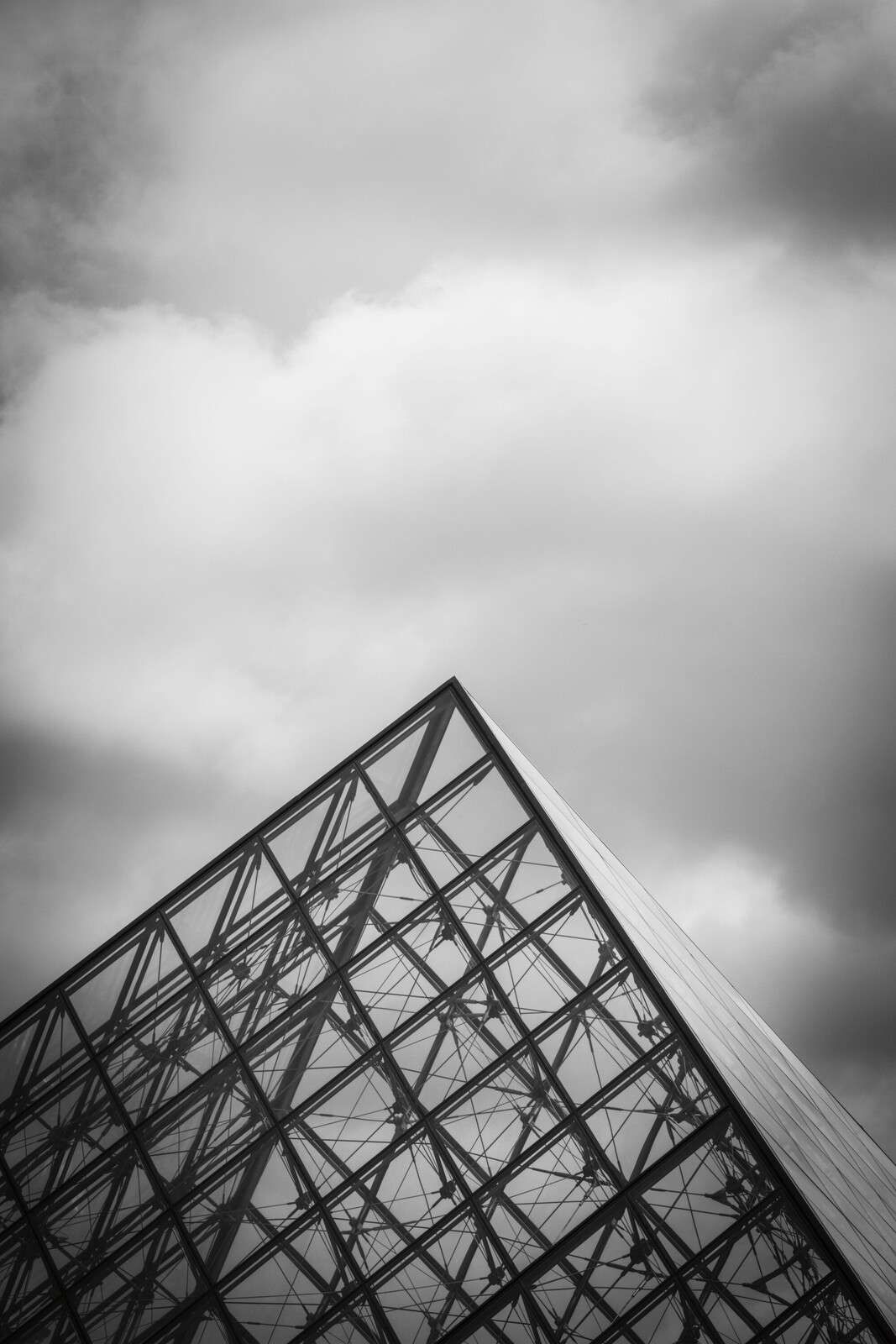 Gläserne Pyramide unter Wolkenhimmel